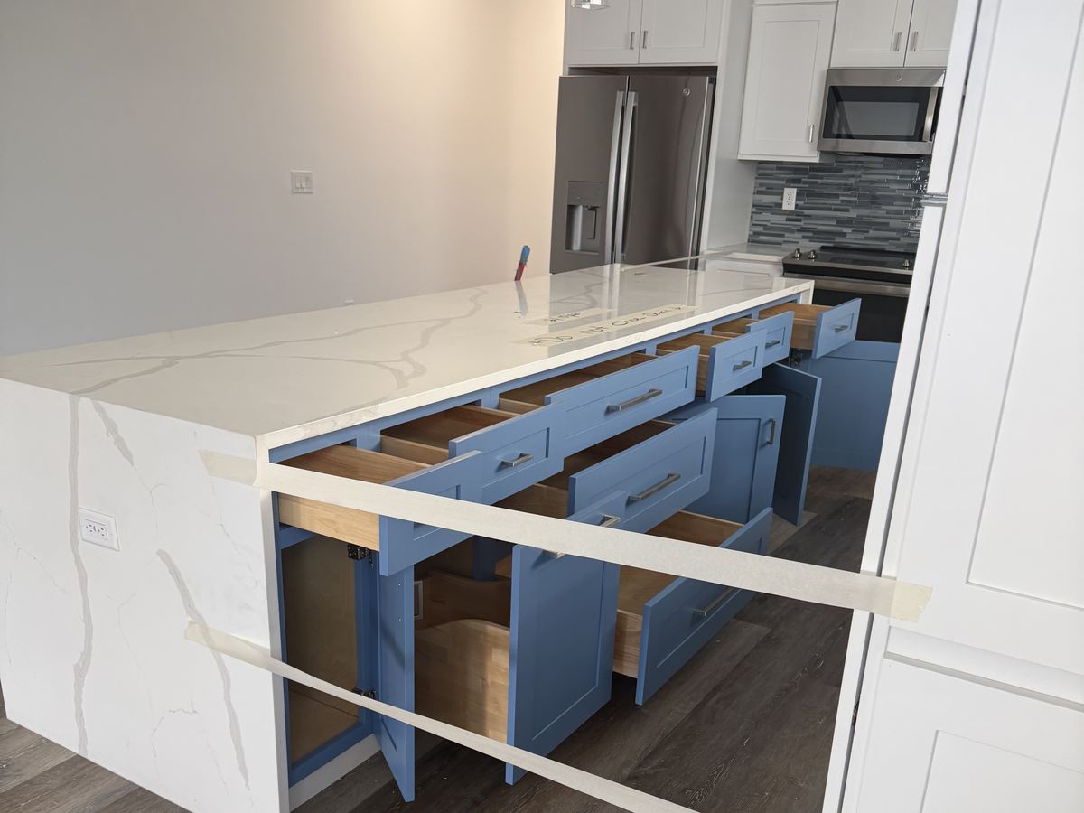 Kitchen island cabinets being refinished with drawers removed and surfaces masked