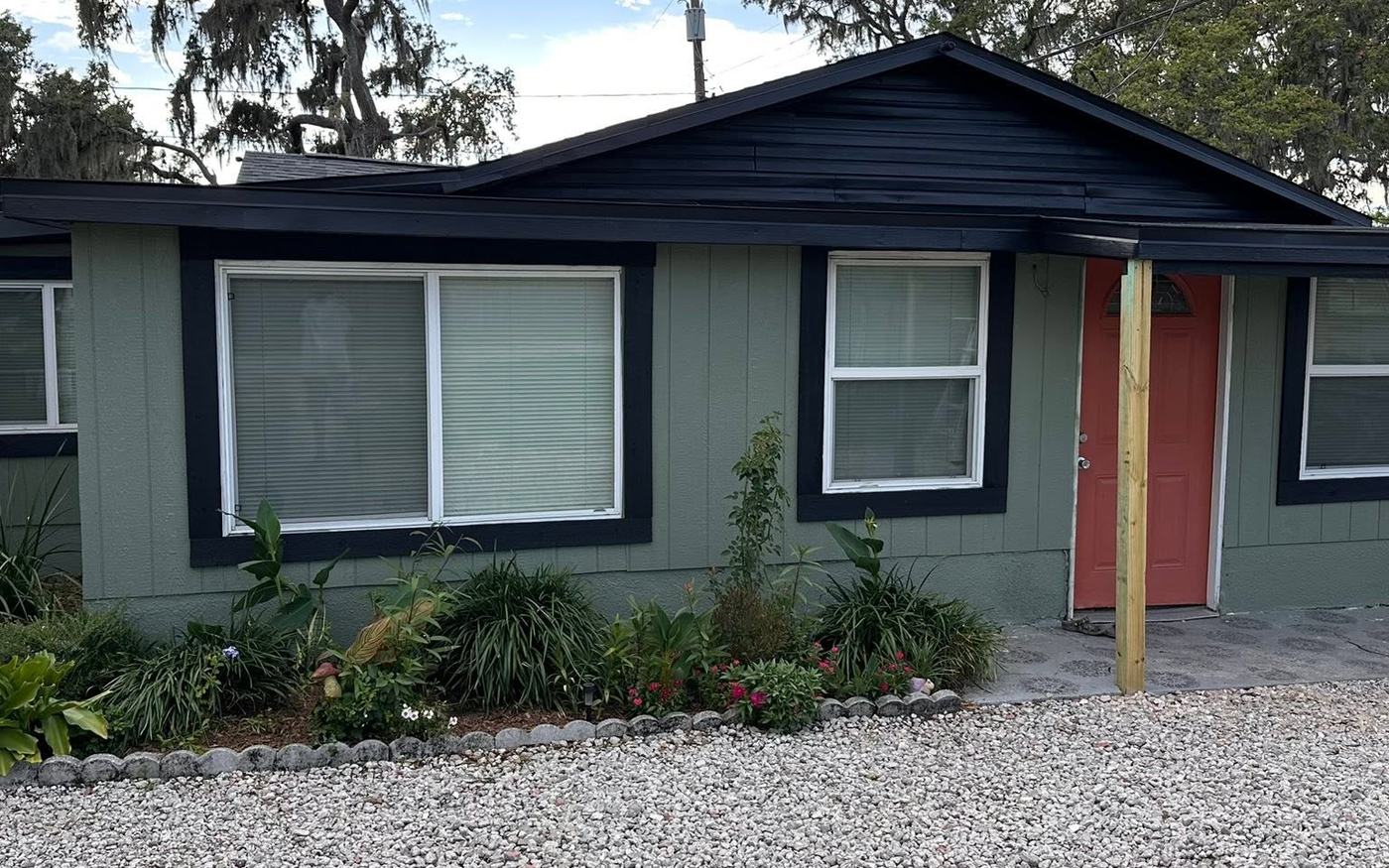 Home with dark exterior and red door